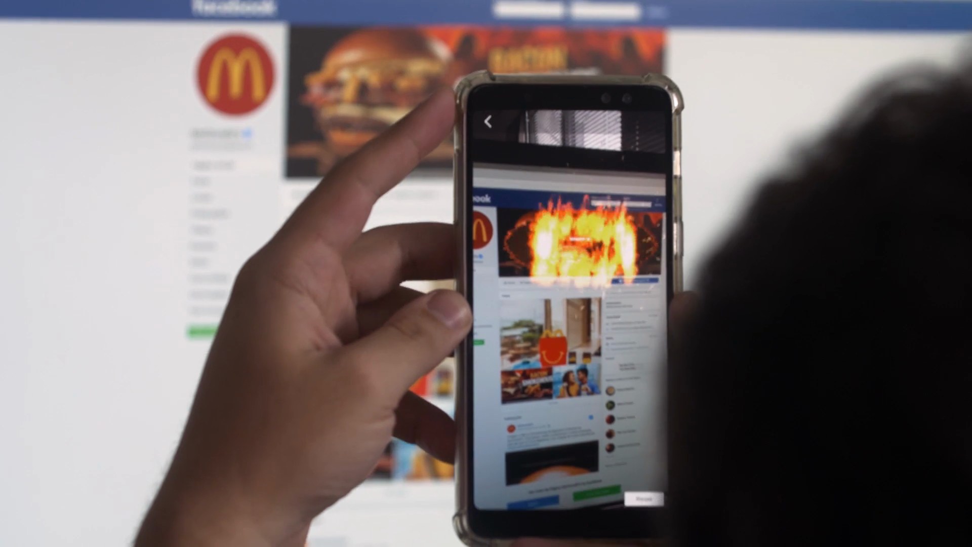 A phone screen showing a rival ad on fire inside the Burger King app