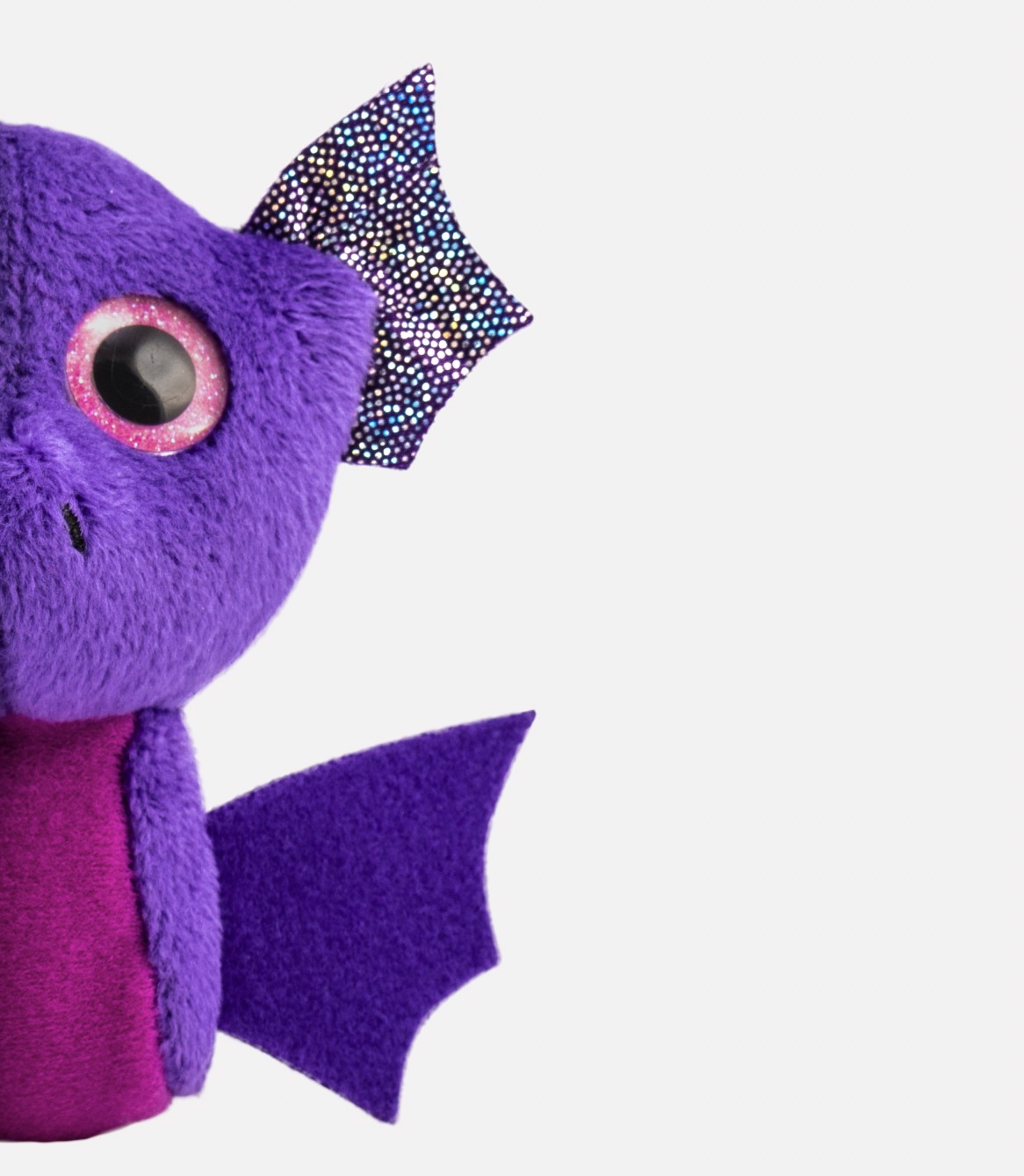 Macro of a purple felt bat toy with a sequin eye