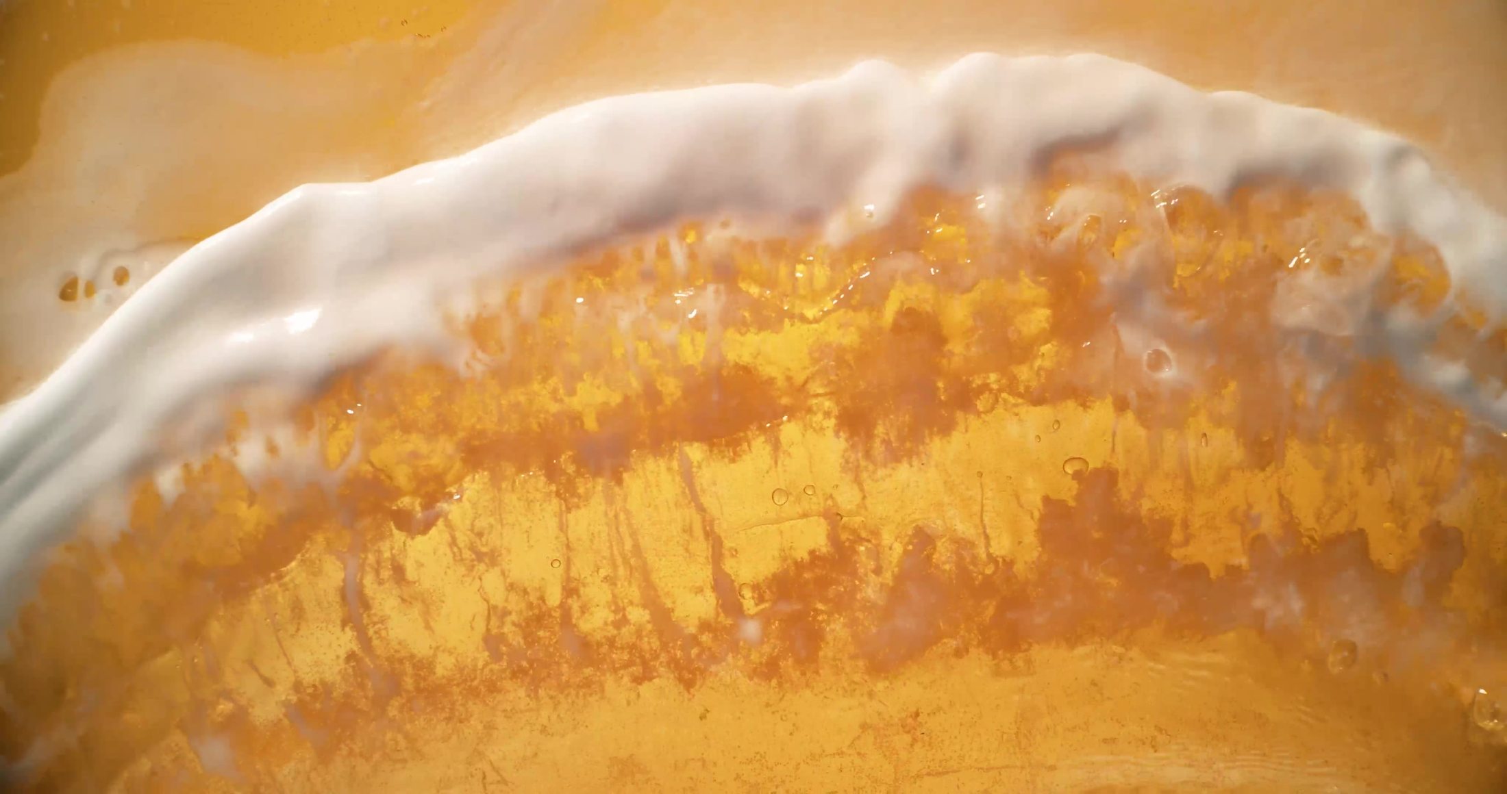 Macro frame of Corona pouring, the head of foam breaking exactly like surf