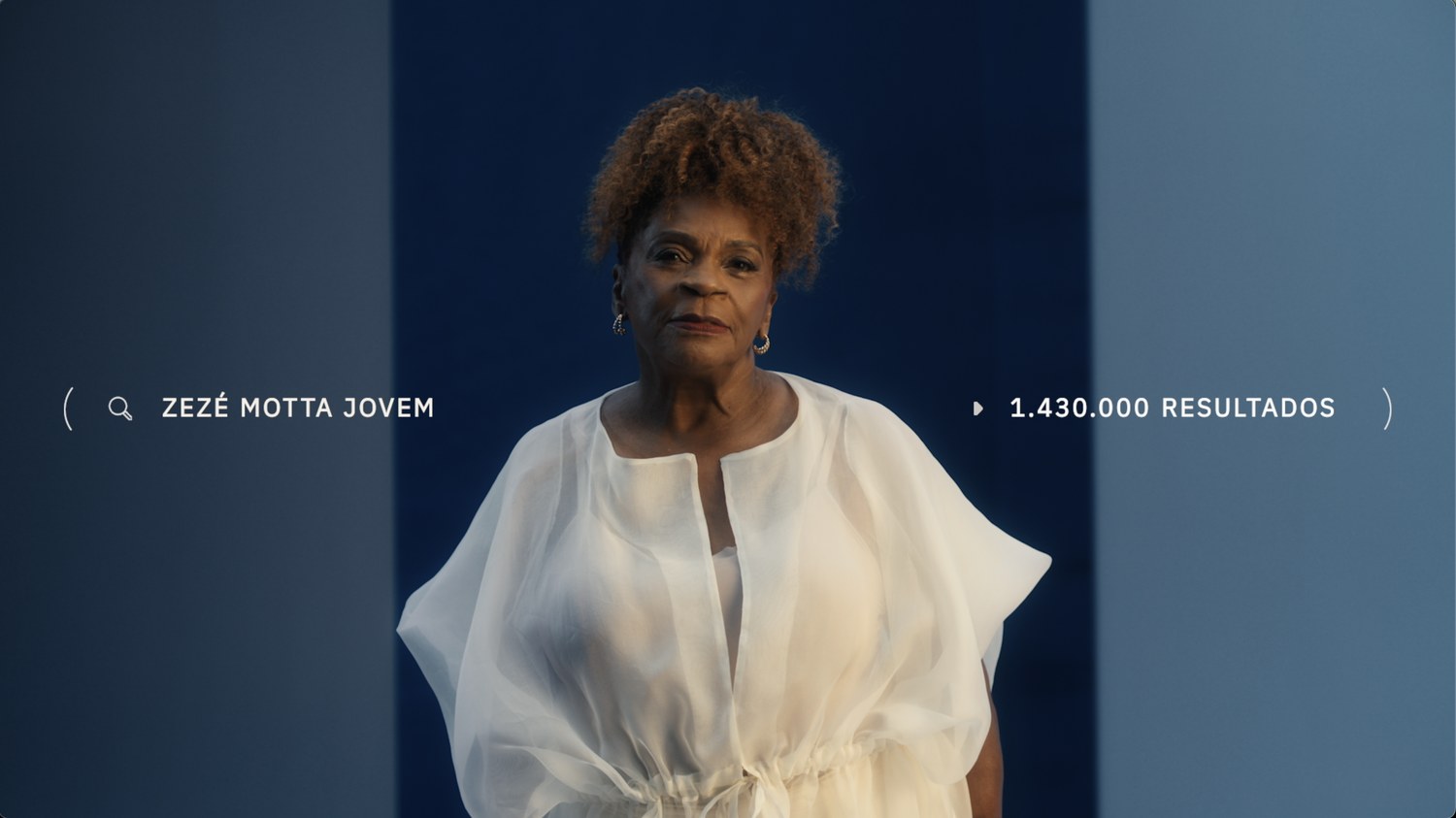 An older actress in white, the on screen search asking how she looked when young